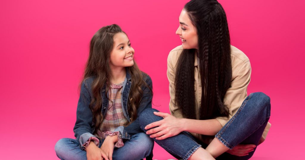 A mom who is talking to her daughter about something and they are smiling on each other