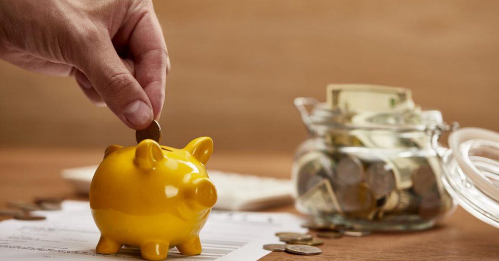 A coin being put in the piggy bank